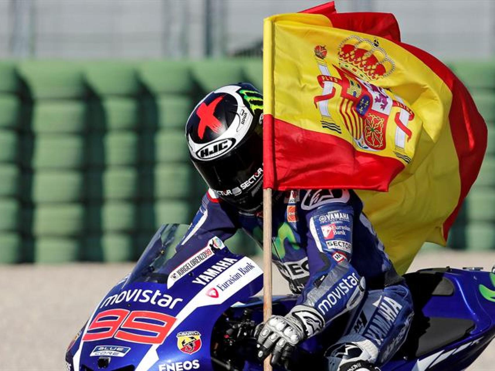El piloto porta una bandera tras ganar la carrera.