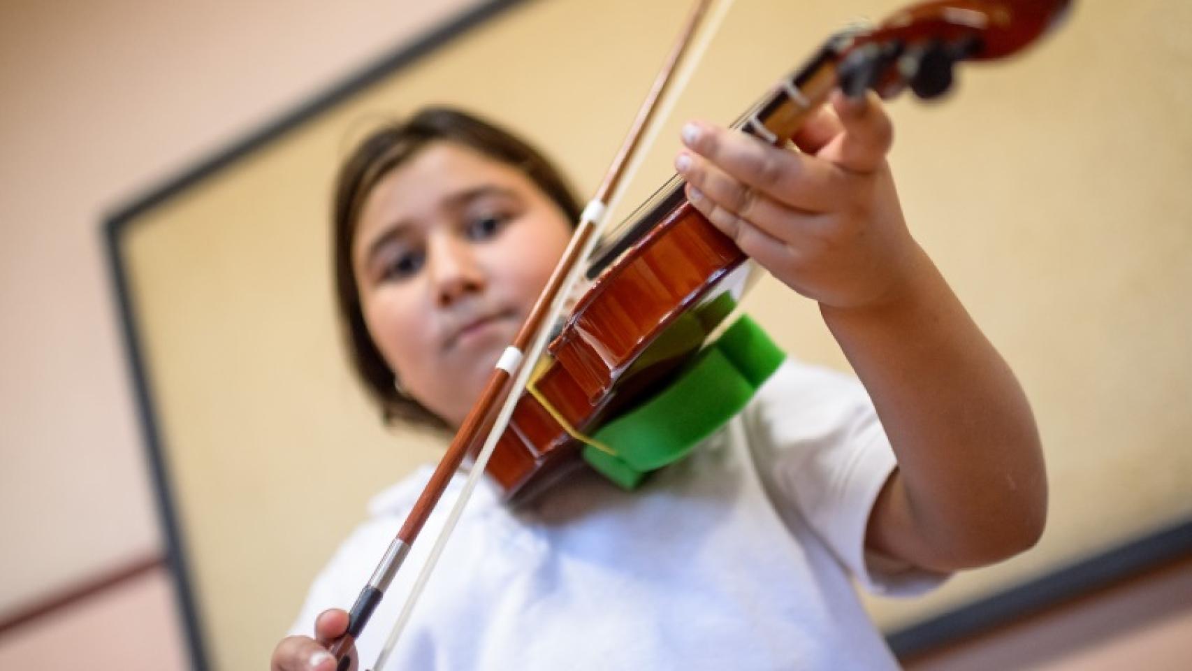 Luis tocando su violín dañado.