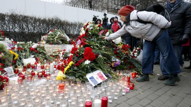 Una mujer coloca flores cerca de la embajada francesa en Moscú