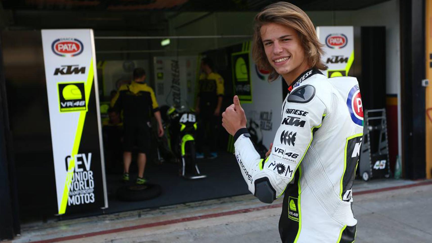 Nicolò Bulega posa sonriente junto al box del equipo júnior de Valentino Rossi.