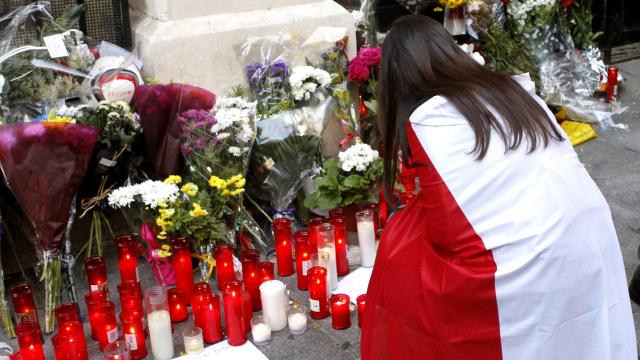 Una joven con la bandera francesa se solidariza con los ataques ante la embajada.