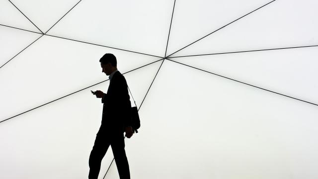 Un hombre camina mientras consulta el móvil.