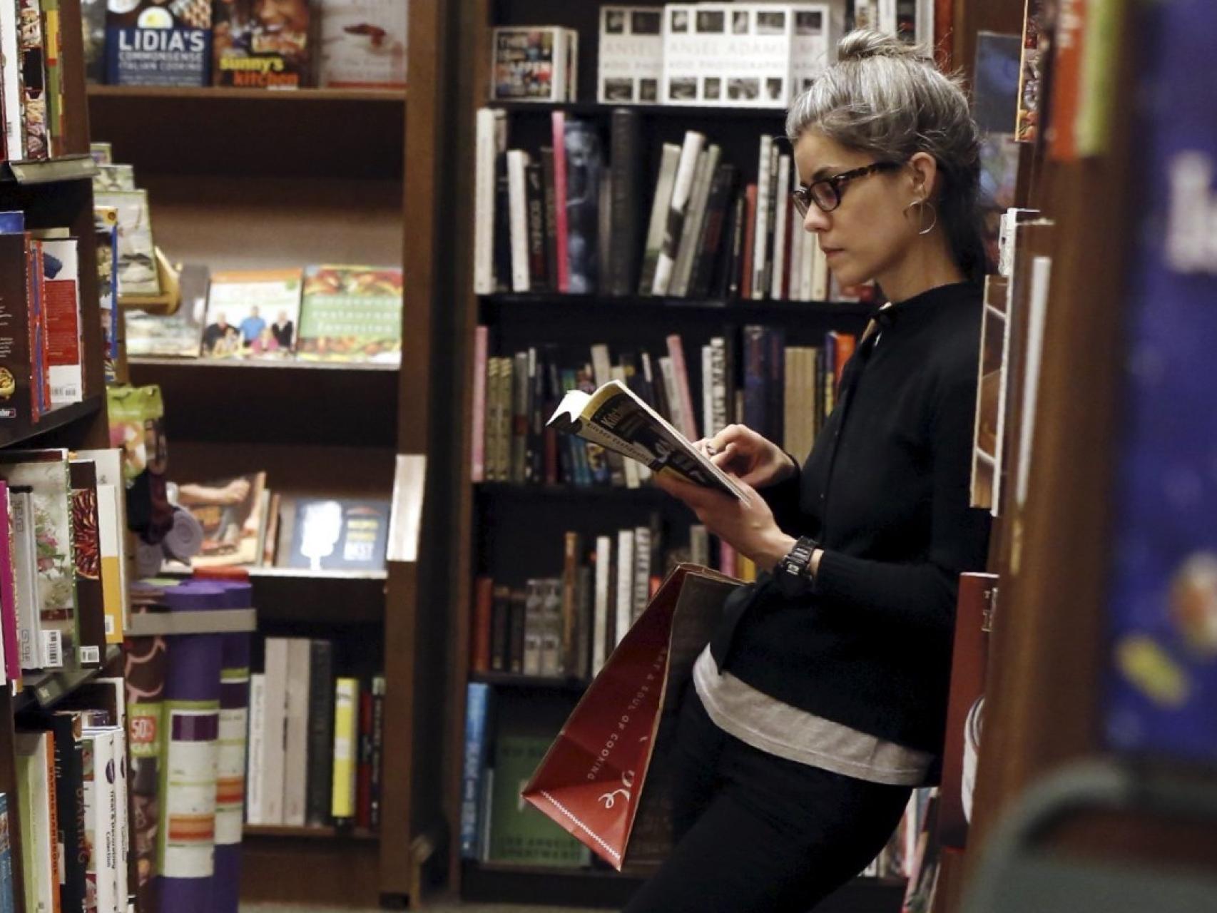 Una mujer leyendo en una librería.