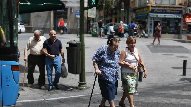 Una mujer, ayudada a cruzar la calle.