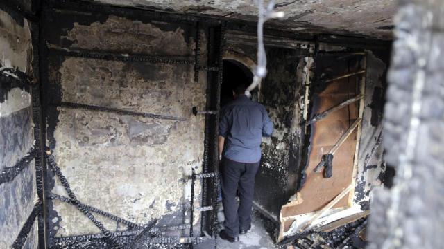 Un policía inspecciona los restos del incendio.