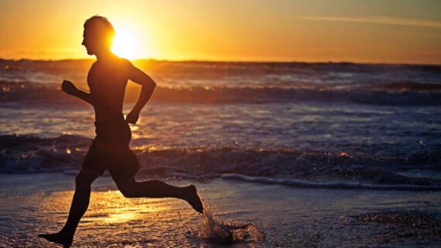 Un joven corriendo por la playa.