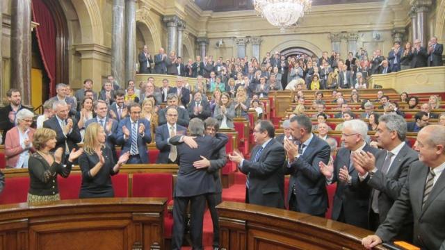 El Parlament aplaude el abrazo entre Artur Mas y Carles Puigdemont.