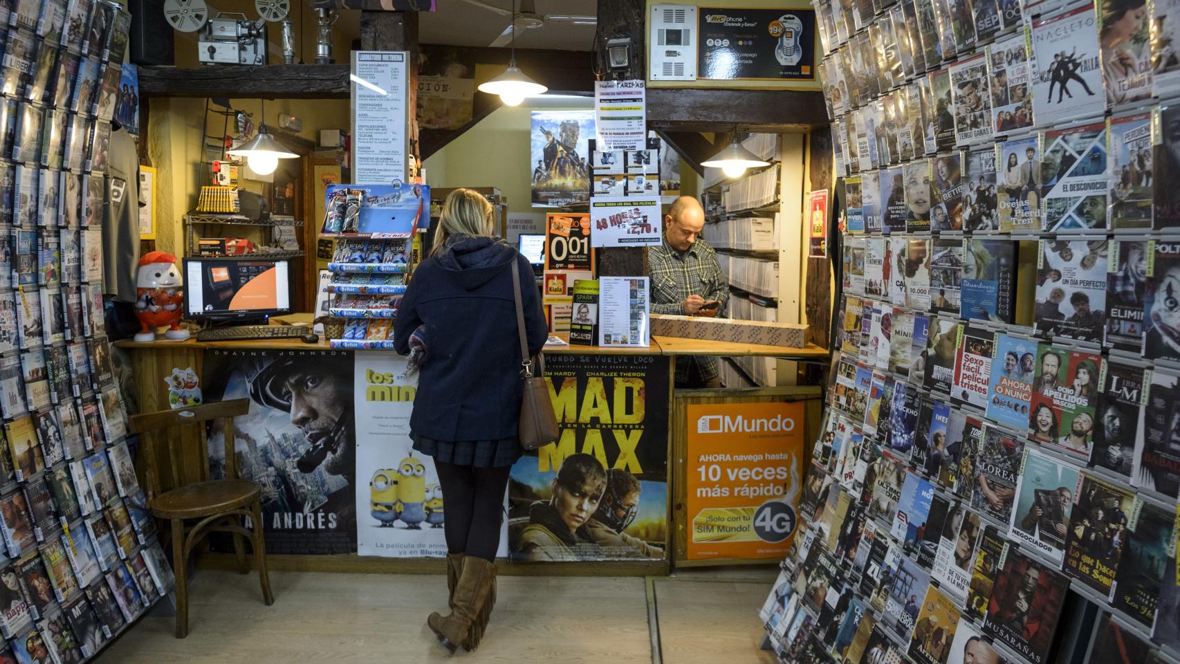 Un cliente alquila una película en un videoclub