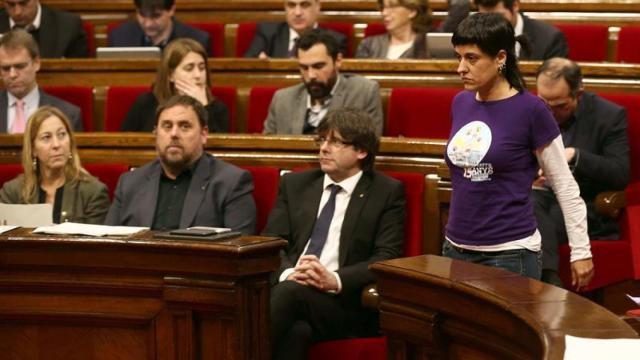 La diputada de la CUP, Anna Gabriel pasa ante el presidente de la Generalitat, Carles Puigdemont