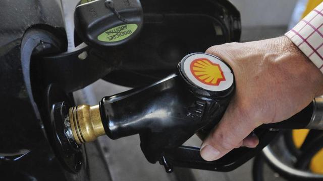 Un conductor reposta su propio coche.