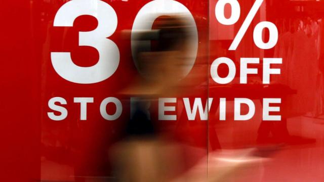 Un consumidor pasa ante un cartel que anuncia rebajas.