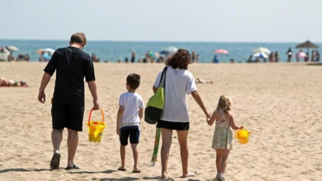 Una familia se dispone a disfrutar de la playa de la Malvarrosa de Valencia