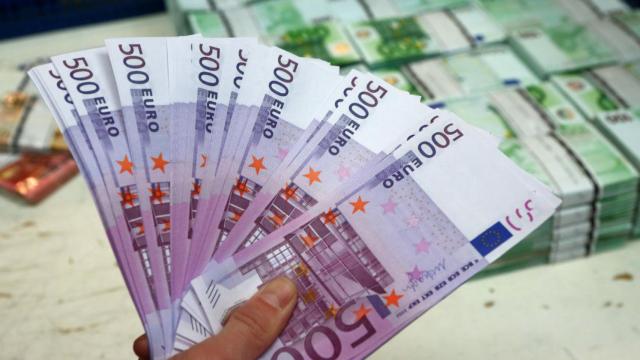 Un empleado de banca sostiene billetes de euro en Viena. /