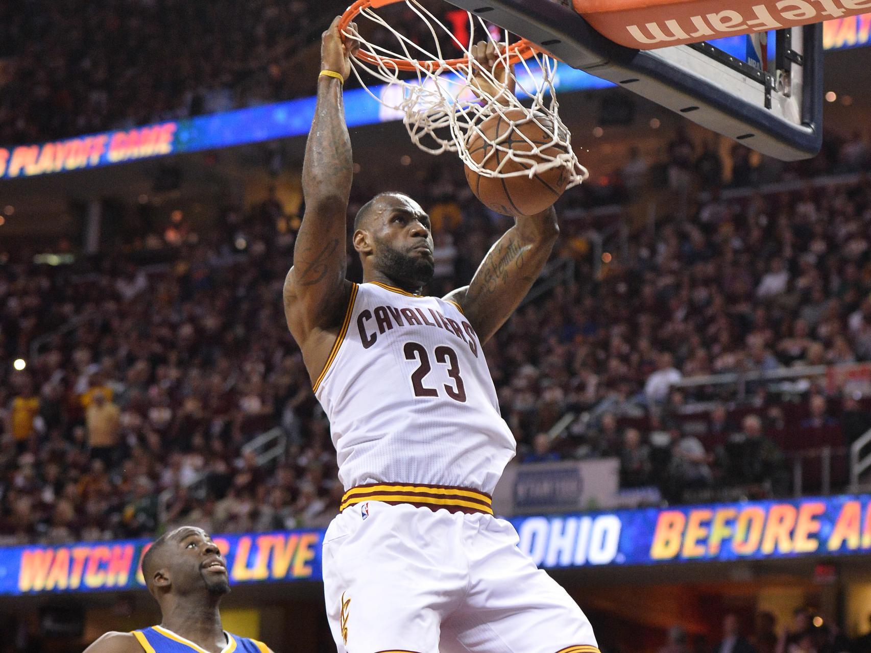 LeBron James machaca frente a Draymond Green.