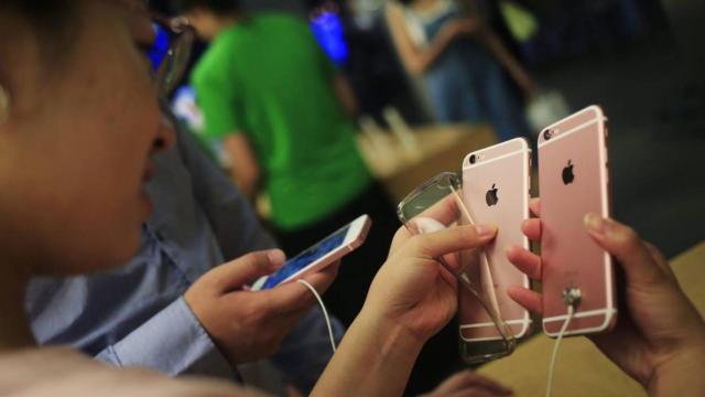 Un joven compara dos iPhone en una tienda.