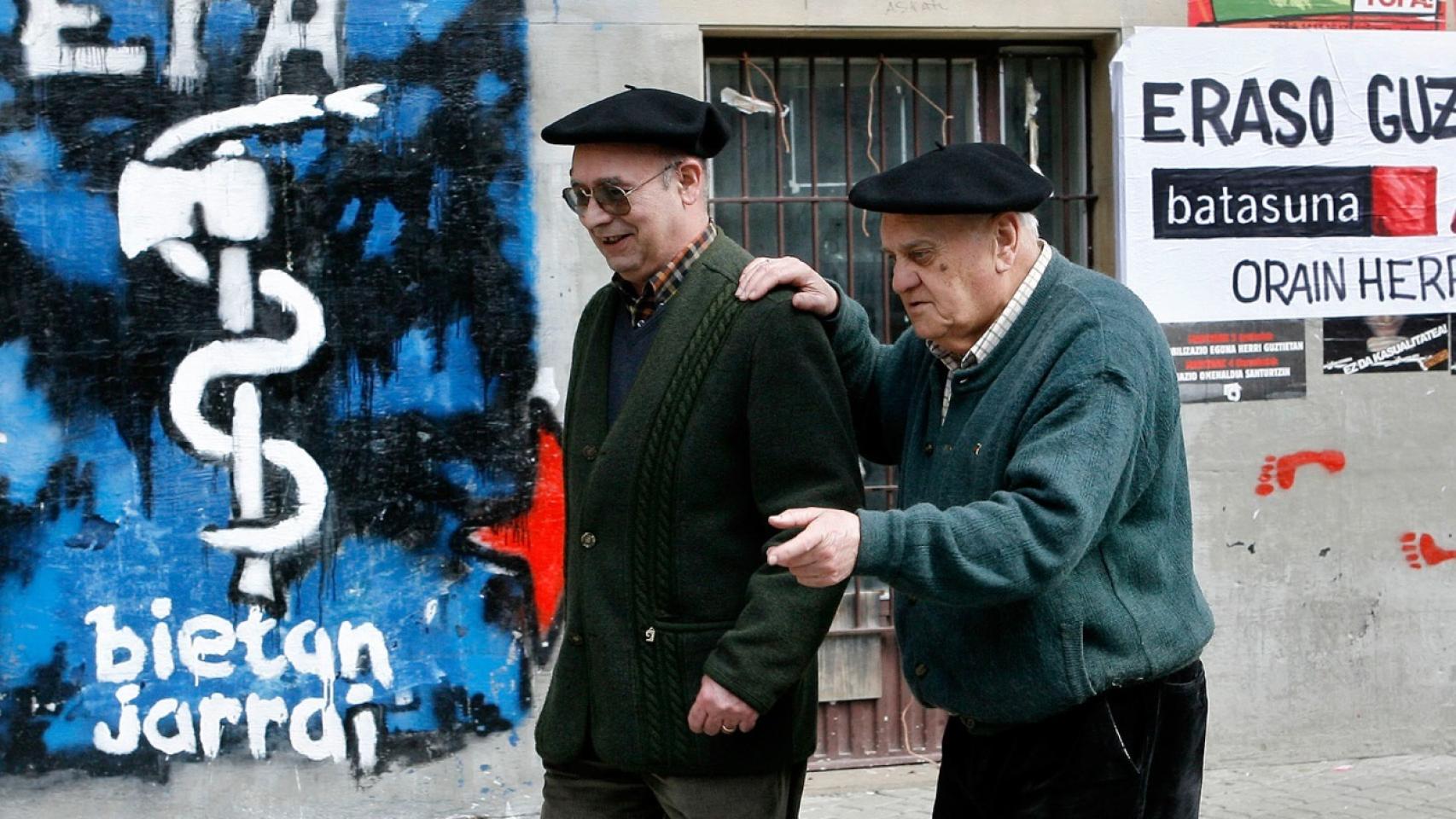 Una foto de archivo de dos ancianos en Alsasua, caminando frente a una pared llena de pintadas de ETA.