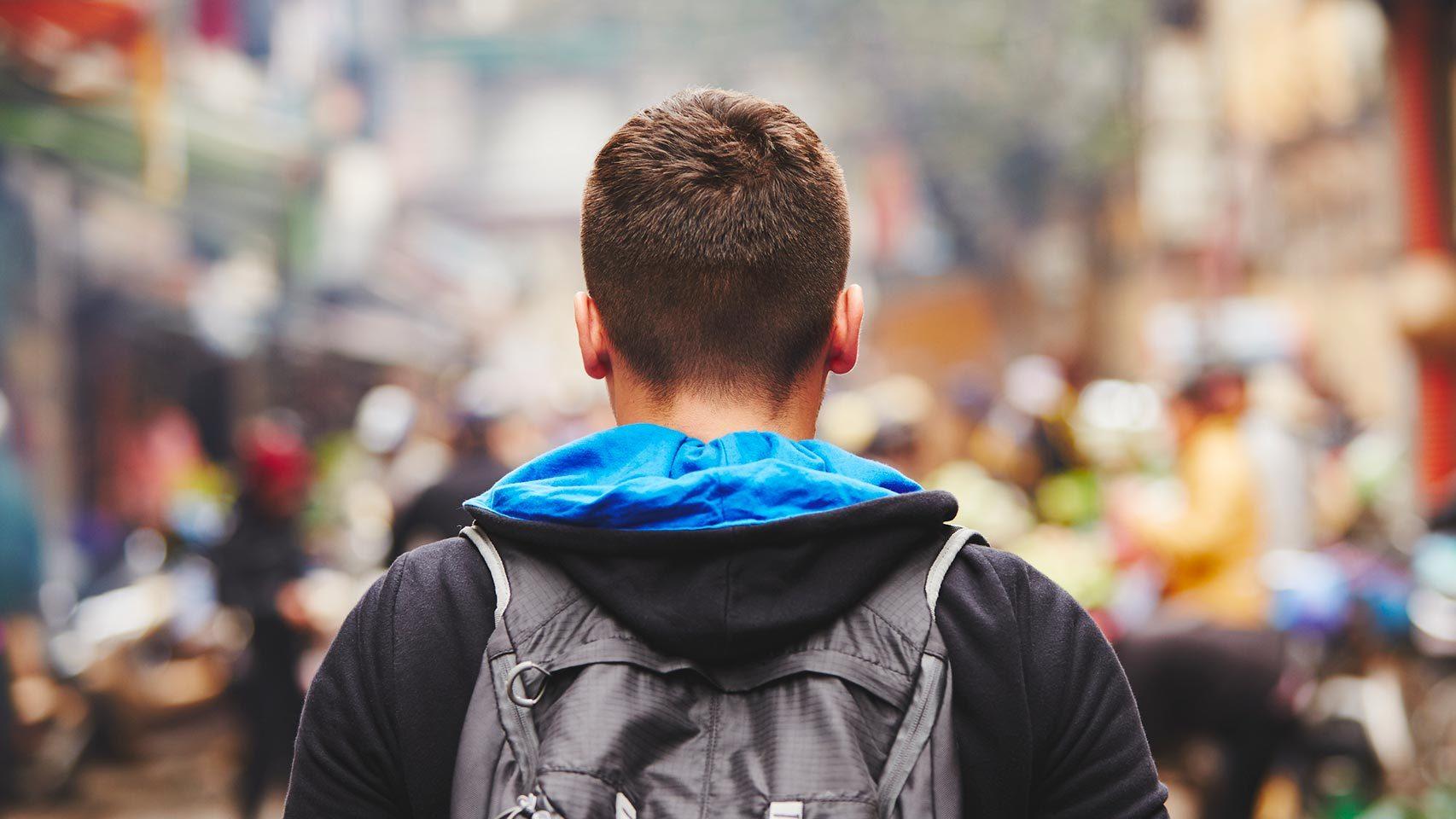 Un joven pasea por una calle.