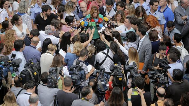Susana Díaz habla rodeada de informadores.