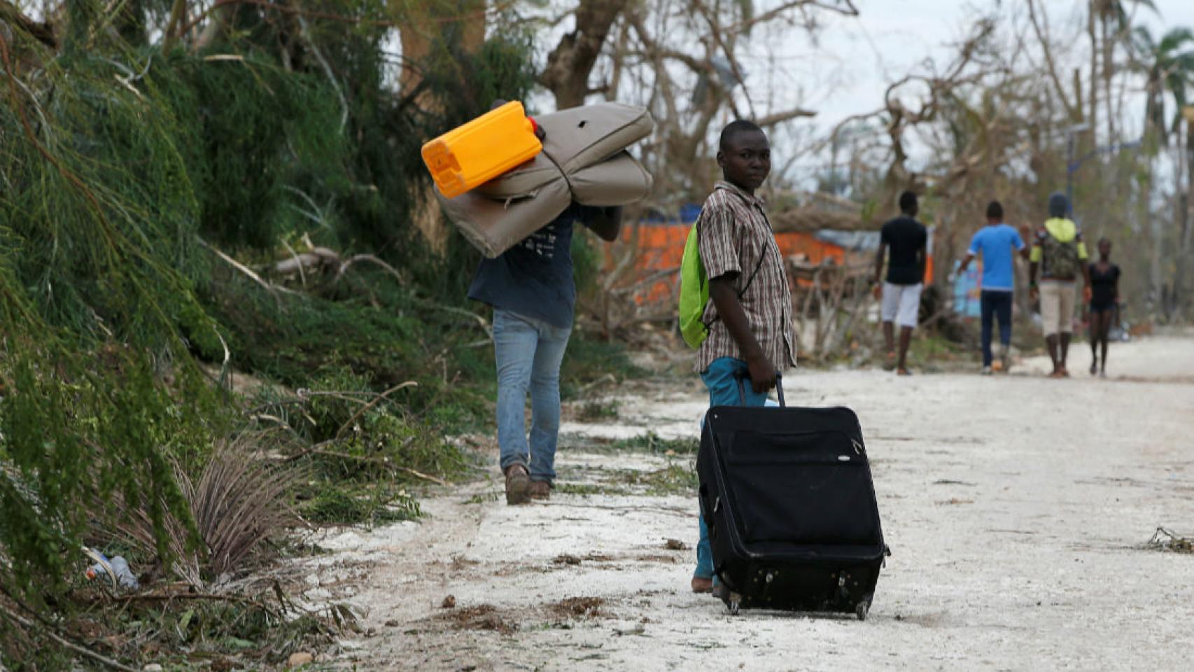 Personas recogiendo sus pertenencias después de que el huracán arrasara sus hogares en Haití.