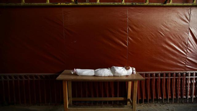 El cuerpo de un niño, envuelto en mortajas, a la espera del funeral.