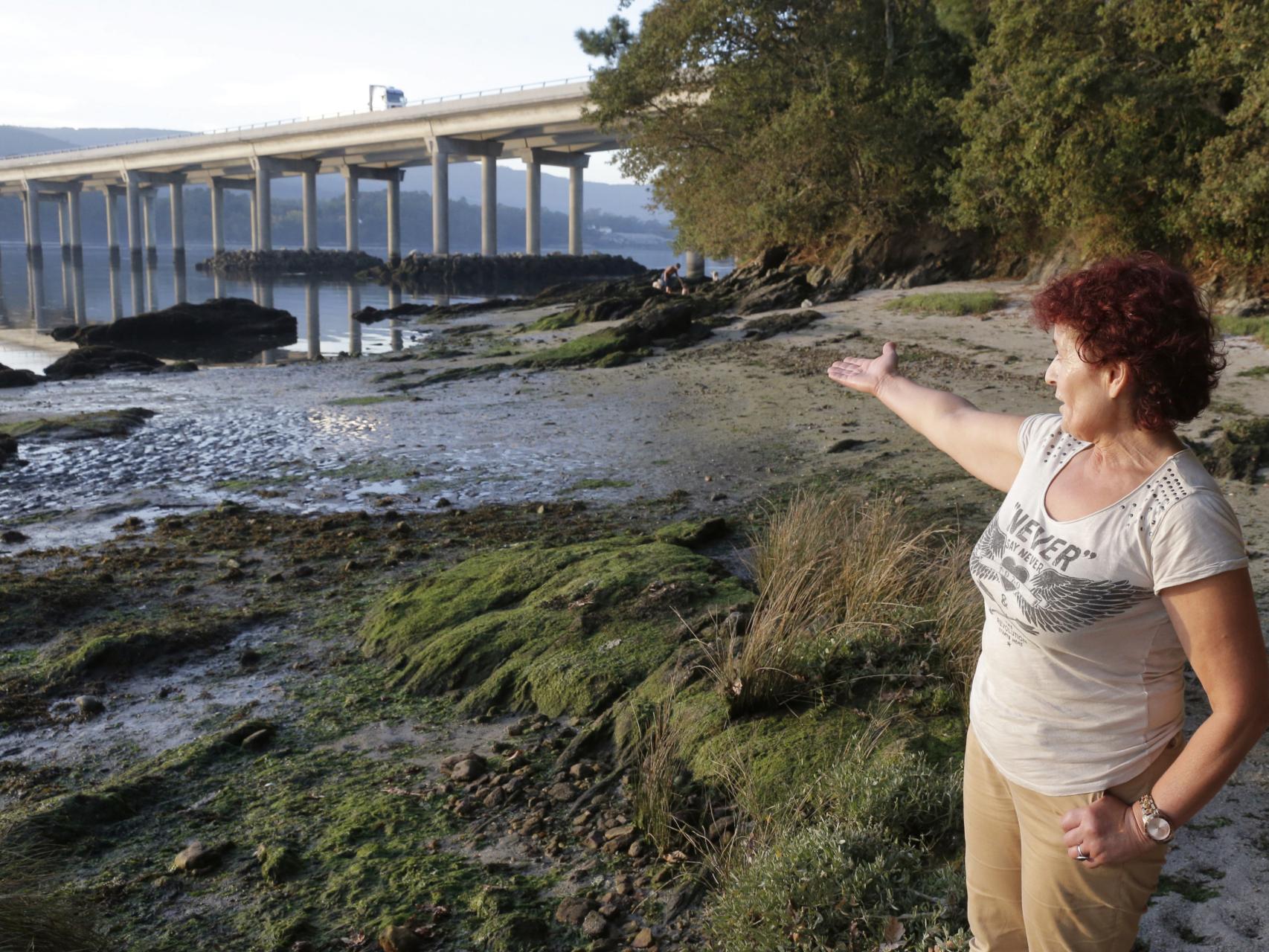 Una mujer señala el lugar donde apareció el teléfono.