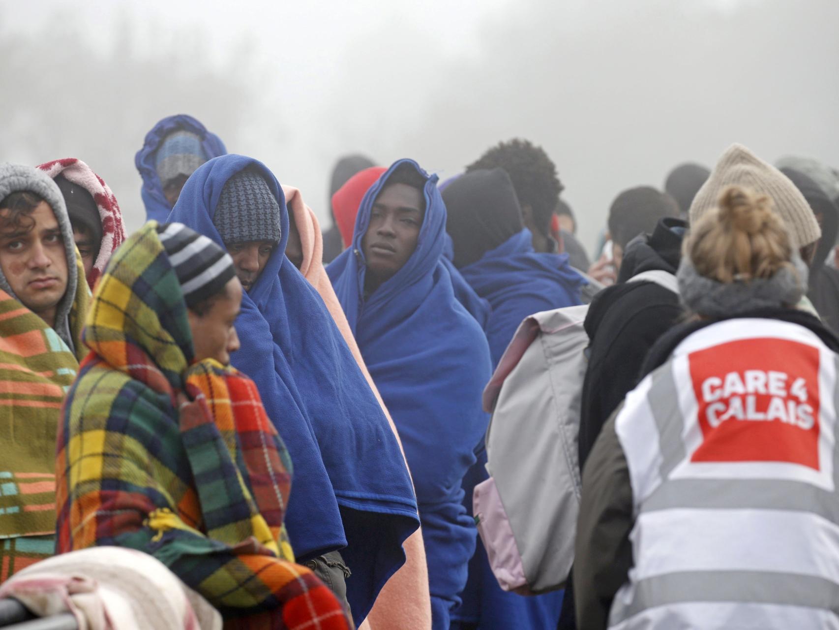 Personas que afirman ser menores hacen cola en Calais para registrarse.