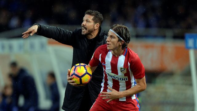 Simeone da instrucciones y Filipe Luis saca la pelota a su lado.