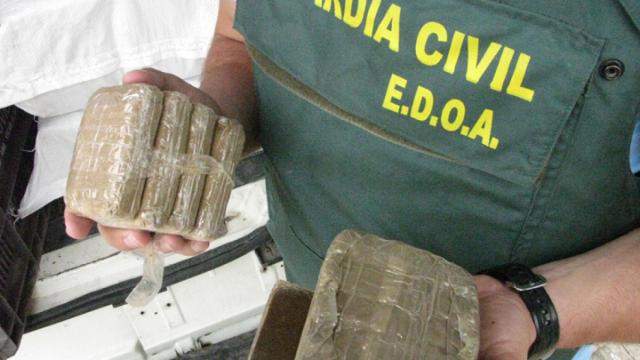 Un agente del EDOA sostiene varias placas de hachís decomisadas durante un operativo de la Benemérita.