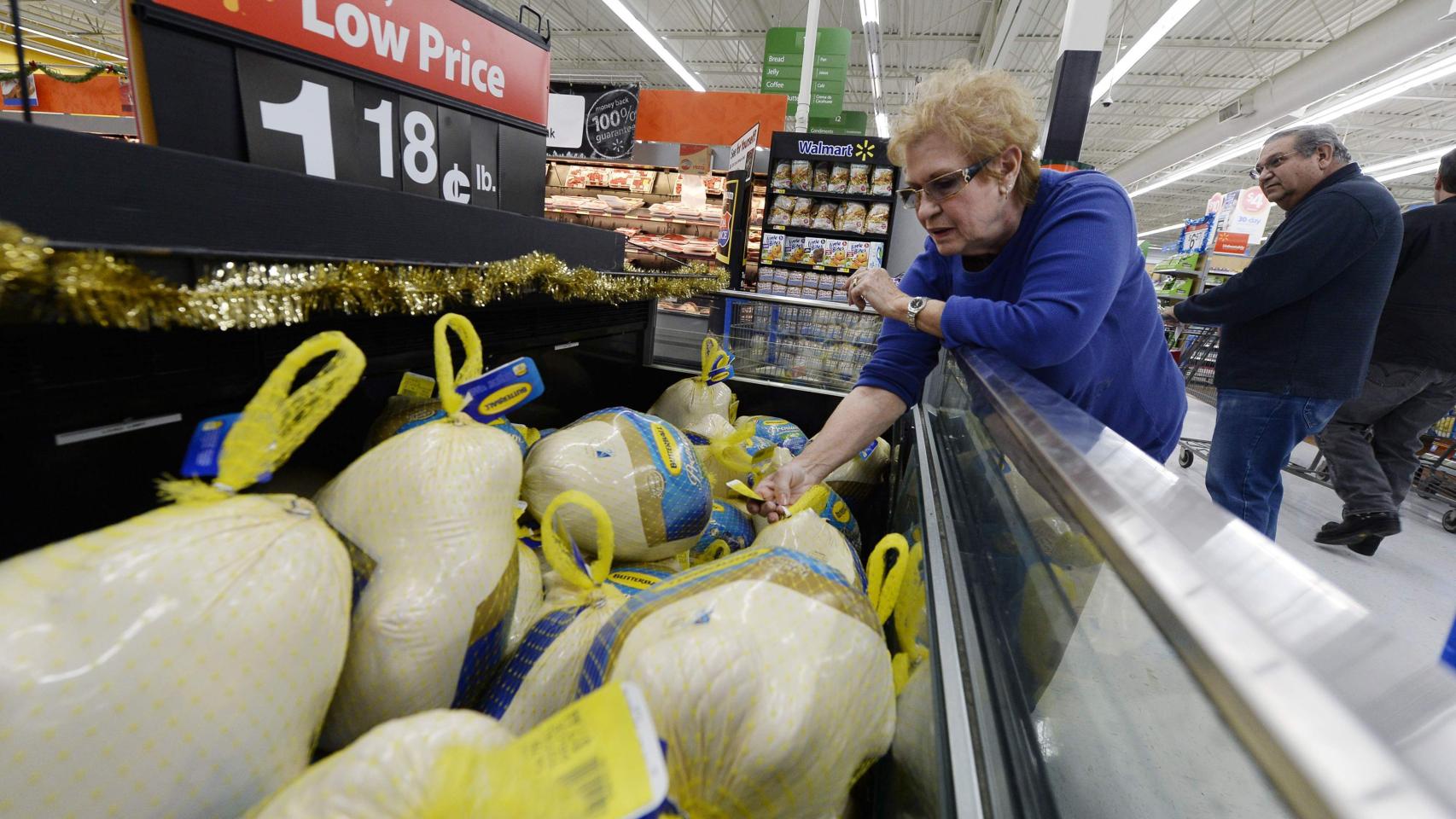 Una clienta toma un pavo en un supermercado de Los Ángeles para Acción de Gracias.