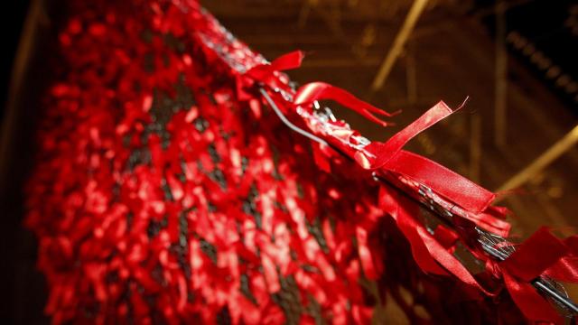 Lazos que forman el gran lazo rojo colocado este jueves en la Puerta de Alcalá de Madrid