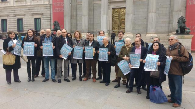 Miembros de la Alianza contra la Pobreza posan con los portavoces de la comisión de Hacienda.