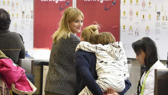 Alba Carrillo sonriente con su madre y su hijo en el aeropuerto de Madrid