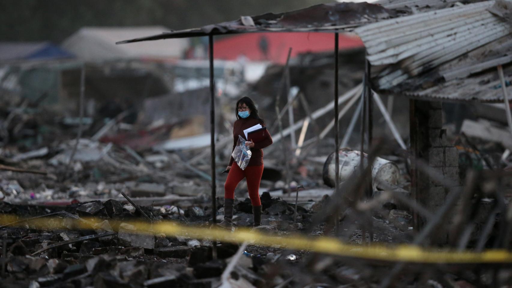 Una mujer camina entre las casas destruidas. /Reuters