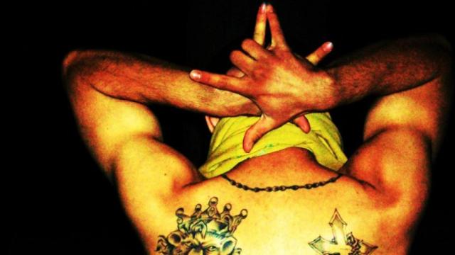 Un miembro de los Latin Kings hace un gesto con las manos característico de su banda.
