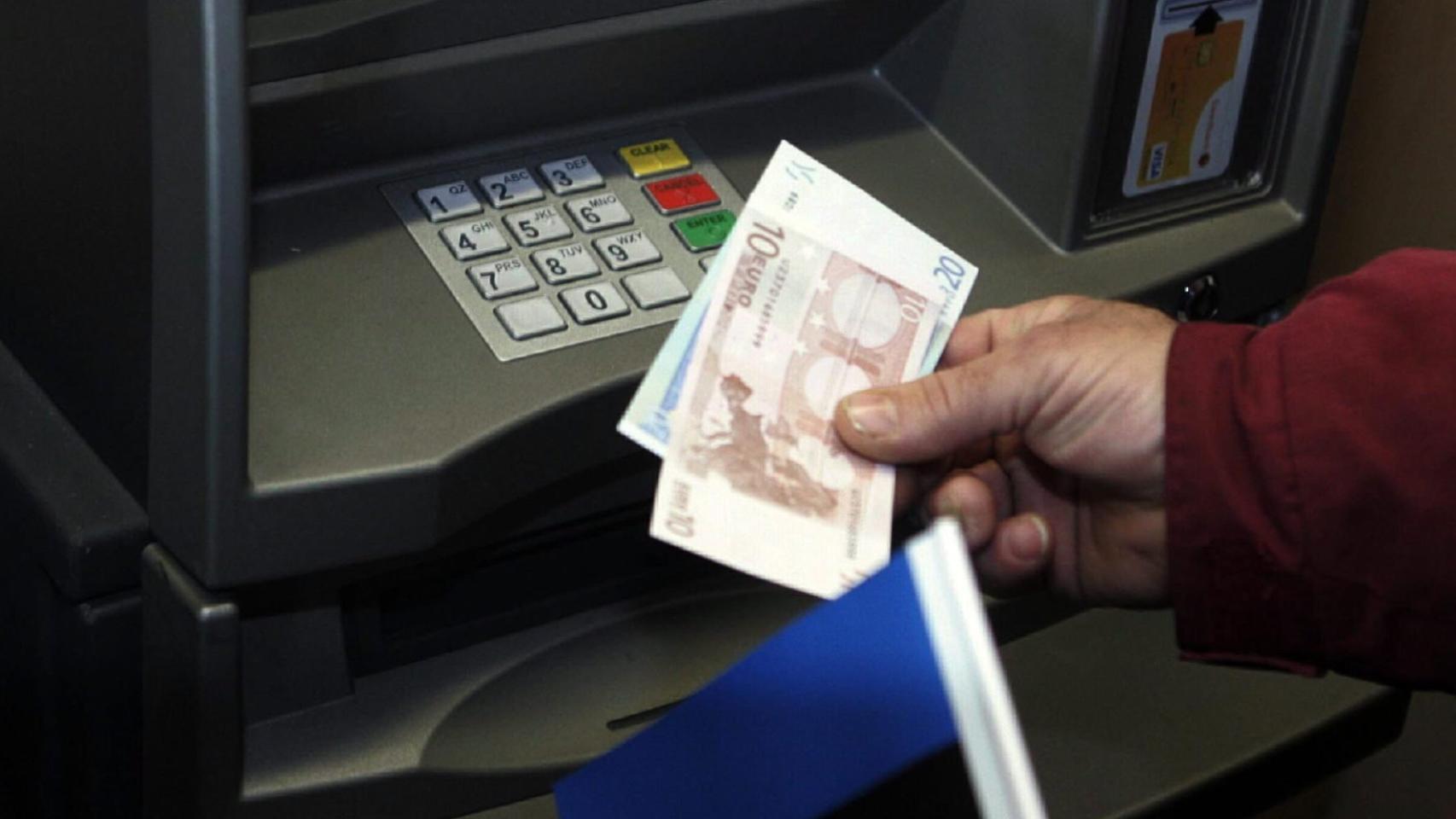 Una persona saca dinero de un cajero.