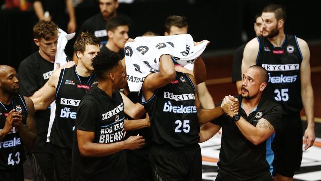 Akil Mitchell abandona la cancha ayudado por sus compañeros.