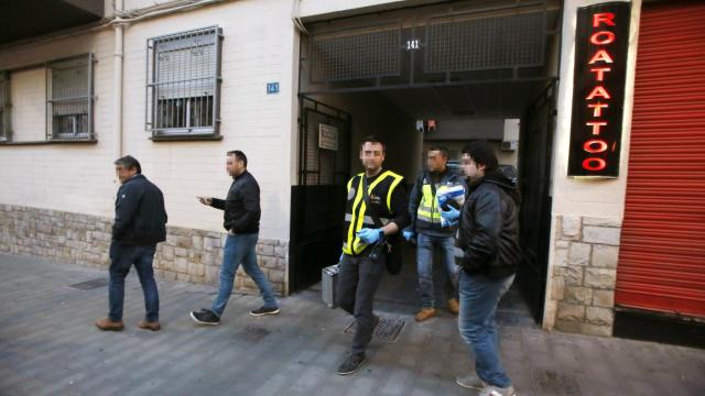 Miembros de la Policía Científica salen del interior del edificio donde vivían las víctimas.
