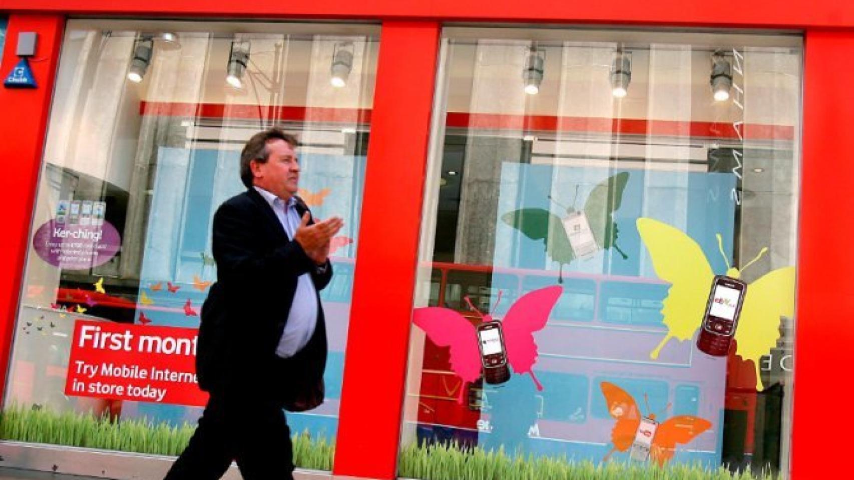 Un hombre pasa ante una tienda de Vodafone.