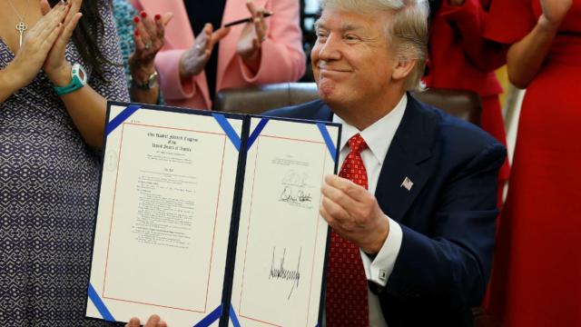Trump muestra su firma estampada en la ley.