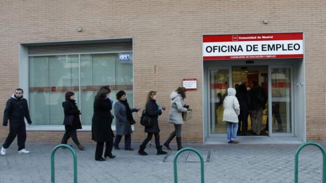 Varias personas hacen cola en una oficina de empleo.