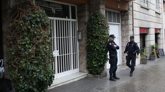 Policías vigilan la entrada del edificio donde se encuentra la vivienda de los Pujol