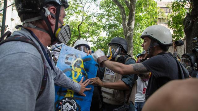 Miguel Gutiérrez (2d), es abordado por manifestantes durante una protesta el lunes.