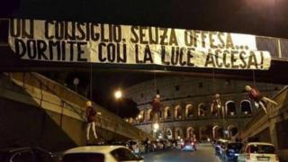 Los muñecos y la pancarta colgados de un puente cerca del Coliseo.