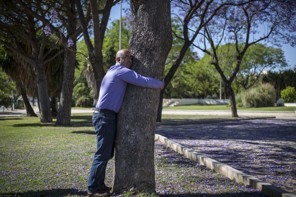 David García, persona con alta sensibilidad, se abraza a un árbol para recuperar energías.