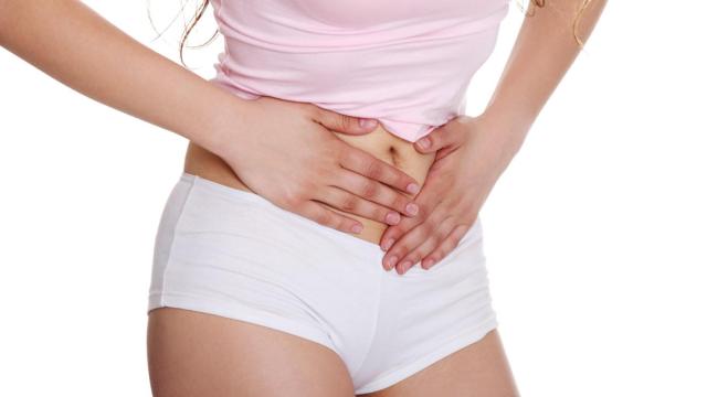 Una mujer pone sus manos sobre la zona en la que están los ovarios.