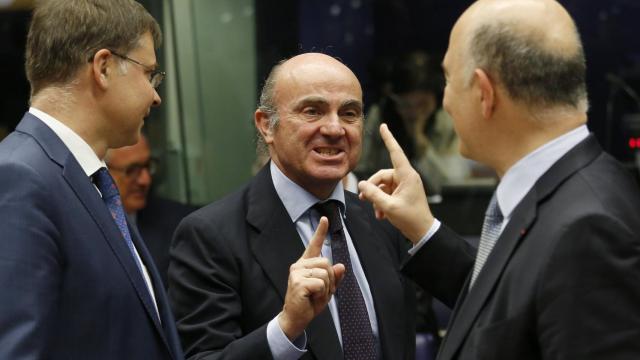 Guindos saluda a Moscovici y Dombrovskis durante la reunión del Eurogrupo