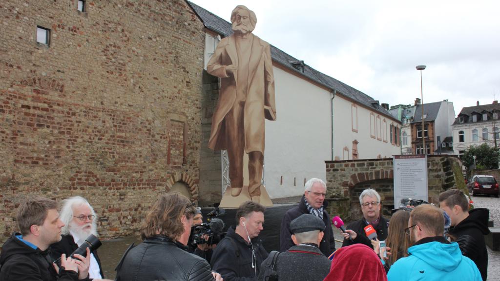 Cartel impreso que emula la estatua de Karl Marx en su ubicación prevista en Tréveris