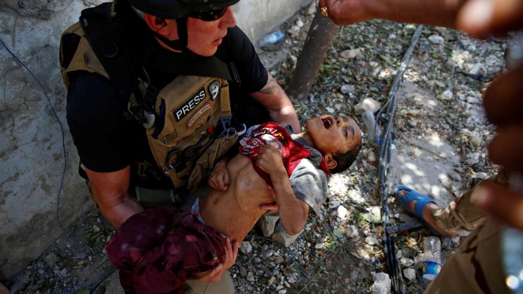 Un soldado iraquí da agua a un niño rescatado en la zona oeste de Mosul