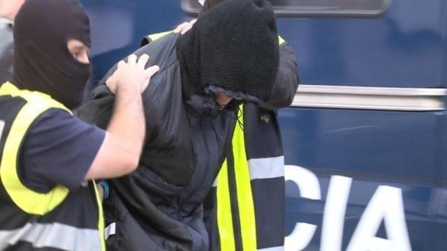 Un agente detiene a un yihadista.