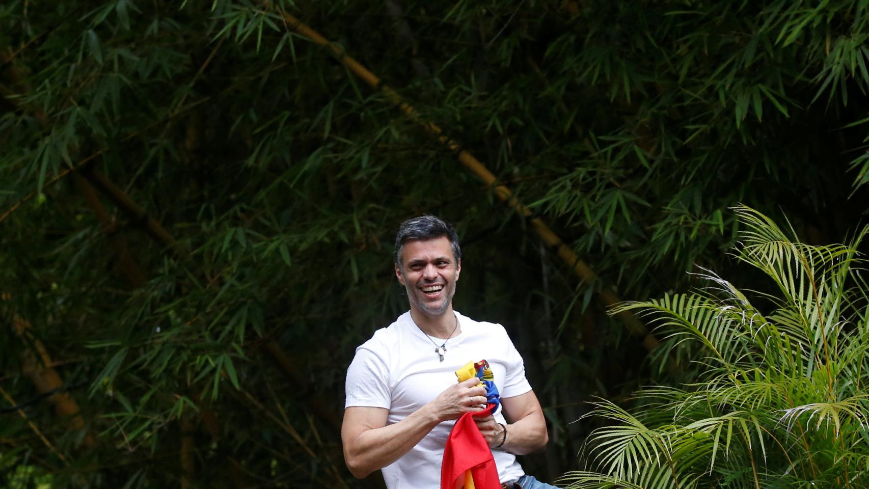 Leopoldo López sostiene una bandera de Venezuela después de ser liberado